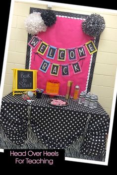 a welcome back table with black and white polka dot cloth, pom poms