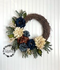 a wreath with flowers and leaves hanging on the wall