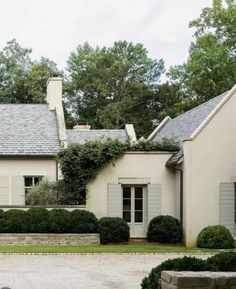 a white house with lots of windows and bushes