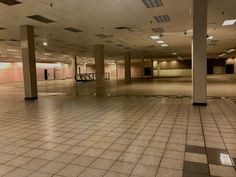 an empty parking garage with tiled flooring and doors on each side, in the middle of a large building