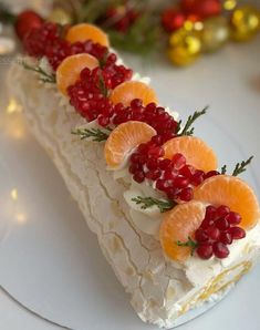 a white plate topped with a cake covered in orange slices and garnishes