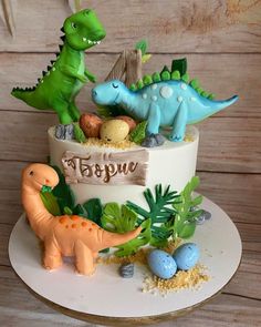 a birthday cake decorated with dinosaurs and eggs