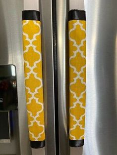 two yellow and white door handles on a stainless steel refrigerator