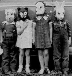 five children wearing animal masks standing in front of an old car with the door open