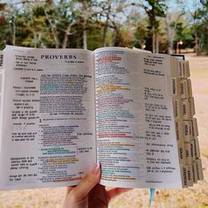 a person holding an open book in their hand with the words proverbs printed on it