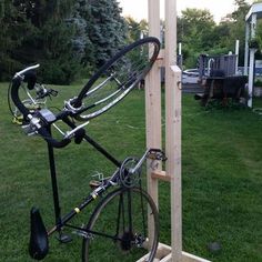 a bicycle is locked to a pole on the grass in front of a playground area