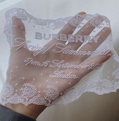 a person's hand is covered with white lace and the words burbery are written on it