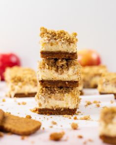 three pieces of cake sitting on top of each other next to crackers and apples