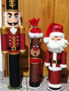 three wooden nutcrackers with santa hats on them