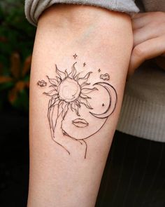 a woman's arm with a sun and moon tattoo on it