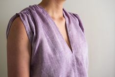 a woman in a purple top is smiling for the camera