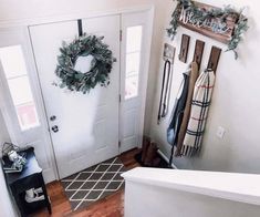 a white door with two wreaths on the front and side of it next to a bathtub