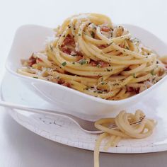 a white bowl filled with pasta on top of a table