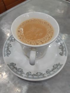 a cup of coffee sitting on top of a saucer next to a countertop