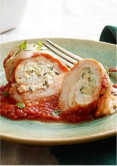 a white plate topped with meat covered in marinara sauce next to a casserole dish