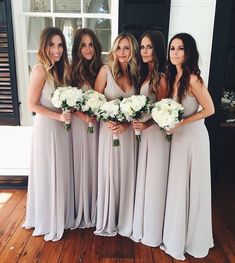 the bridesmaids are all dressed in gray dresses and holding their bouquets together