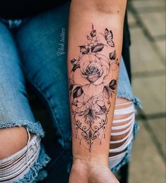 a woman's arm with a rose tattoo on it