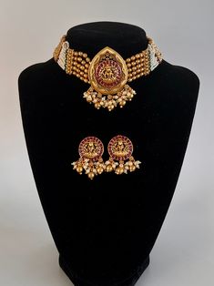 Beautiful 3pcs Choker Set in Antique Gold Finish Stone and Pearl Work. The jewelry beautifully displays craved images of Goddess Laxhmi Image on a Lotus on the necklace as well as on the Earring. Item : Choker with earring Work : CarvingColor : Gold Antique Finish Length of the necklace without chain : 8.5inches Length of Centerpiece : 1.3 inches Width of Centerpiece : 2.2 inches Length of Earrings : 1.5 inches (with pearls)Shop Polices -- Please note Jewelry is delicate, please hand with care a Intricate Design Sets For Festivals And Gifts, Intricate Design Sets As Festival Gifts, Handmade Kundan Gold Sets, Handmade Kundan Gold Jewelry Set, Handmade Gold Kundan Set, Handmade Gold Kundan Jewelry Set, Gold Jewelry Sets With Motifs As Gift, Handmade Temple Jewelry Sets For Festive Occasion, Festive Gold Fusion Sets