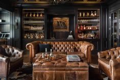 a living room filled with brown leather furniture and lots of bottles on top of shelves