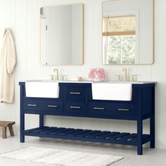 two sinks and mirrors in a bathroom with white rugs on the floor next to it