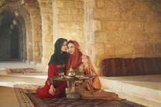 two women are sitting on the floor with food