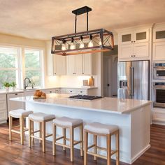 a kitchen island with four stools in front of it and an oven on the other side