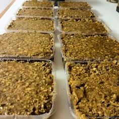 several trays filled with food sitting on top of a white counter next to each other