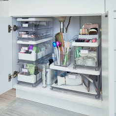 the drawers are organized with various items such as toothbrushes, hairdryers and other personal care products