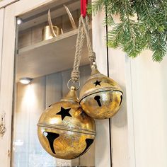 two gold christmas ornaments hanging from a door