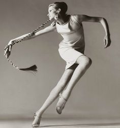 a black and white photo of a woman in ballet clothes with her legs spread out