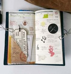 an open planner book with various items on it and a pen next to the pages