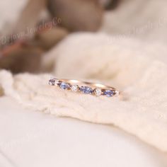 a close up of a ring on a white blanket with a teddy bear in the background