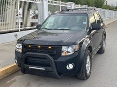 a black suv is parked on the side of the road