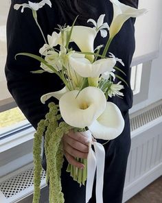 a woman holding a bouquet of white flowers