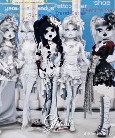 three dolls standing next to each other in front of a poster