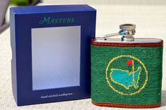 a flask style hip flask next to a blue box with the word masters on it