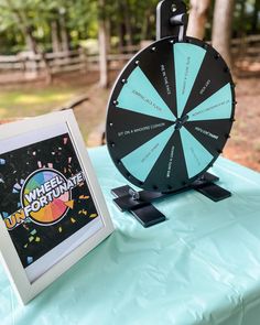 a wheel of fortune game sitting on top of a table next to a framed photo