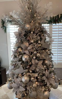 a christmas tree decorated with silver and gold ornaments