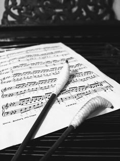 two brushes resting on top of sheet music