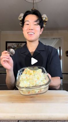 a man holding a spoon in front of a bowl of food