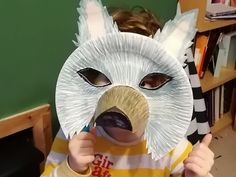 a young child wearing a paper plate animal mask