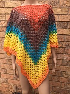 a crocheted top on a mannequin with a brick wall behind it