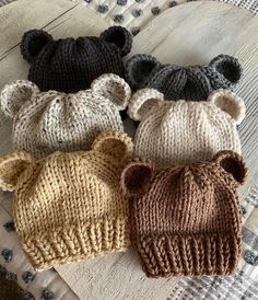 four knitted bears are laying on a bed