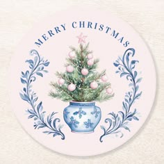 a blue and white christmas ornament with a tree in a vase on it