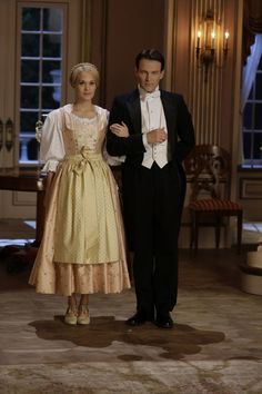 a man and woman in formal wear standing next to each other on a carpeted floor