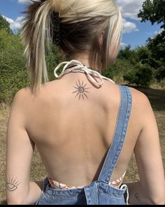 a woman with a sun tattoo on her back