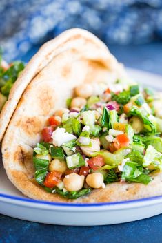 two pita breads filled with vegetables on a blue and white plate