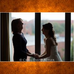 two women standing next to each other in front of a window