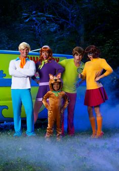 the scooby gang is standing in front of a van