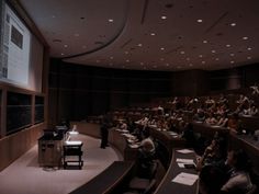 an auditorium full of people sitting in chairs